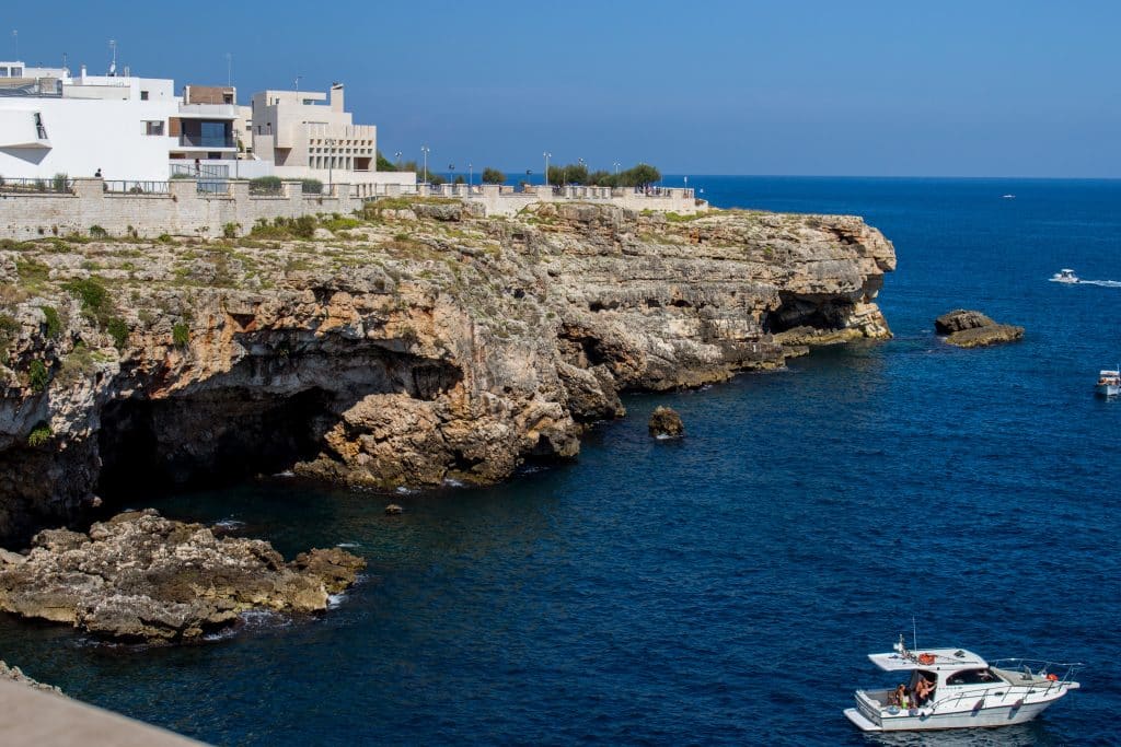 A boat sailing along a rocky coastline in Italy