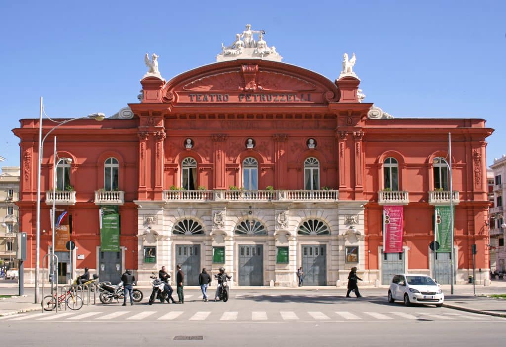 A bright red theater with a curved arch on top. The bottom front of the theater is bright white in contrast.