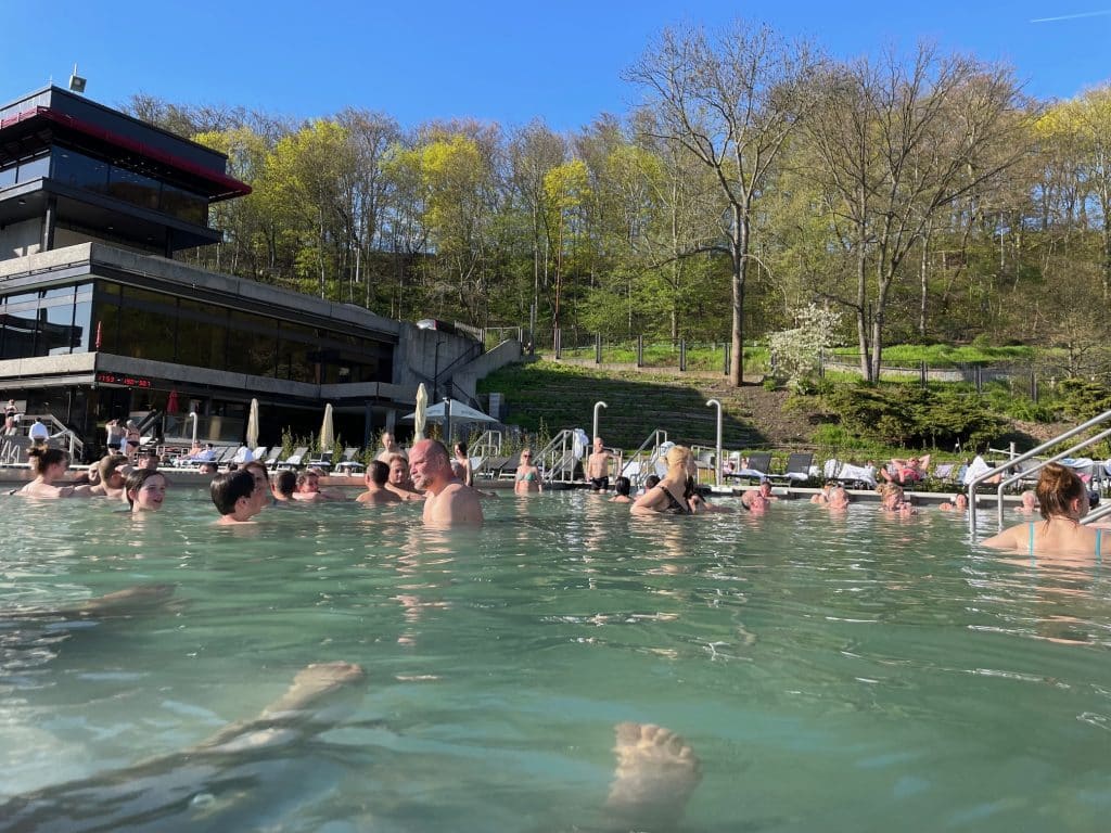 People swimming in a milky green outdoor pool.