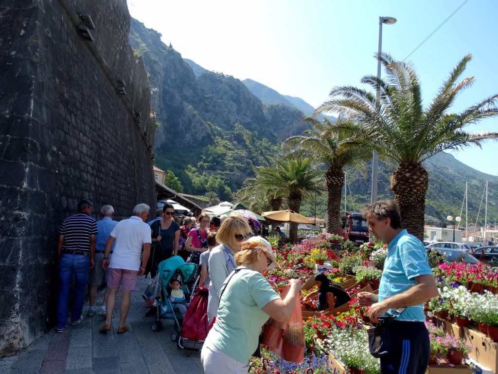 Tourists buying fruit from a market in Kotor, Montenegro.