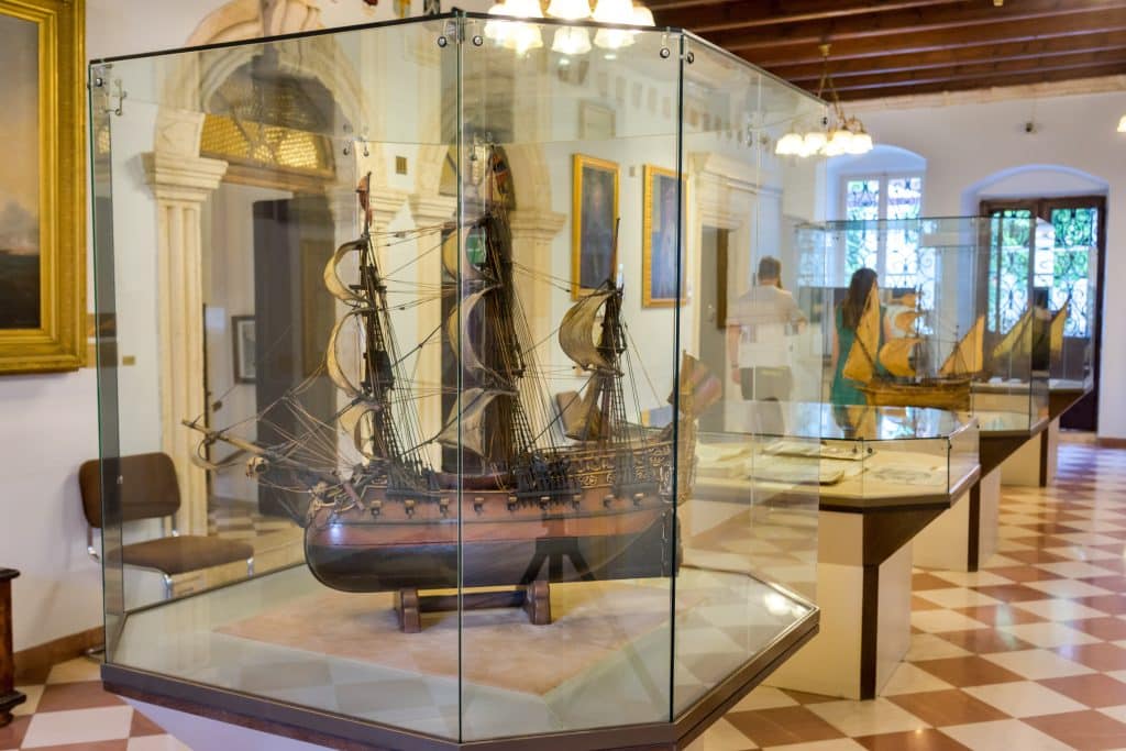 Beautiful model ships behind plate glass in a maritime museum.
