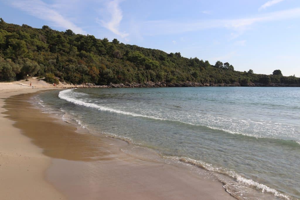 A long, sandy beach with soft, gentle waves.