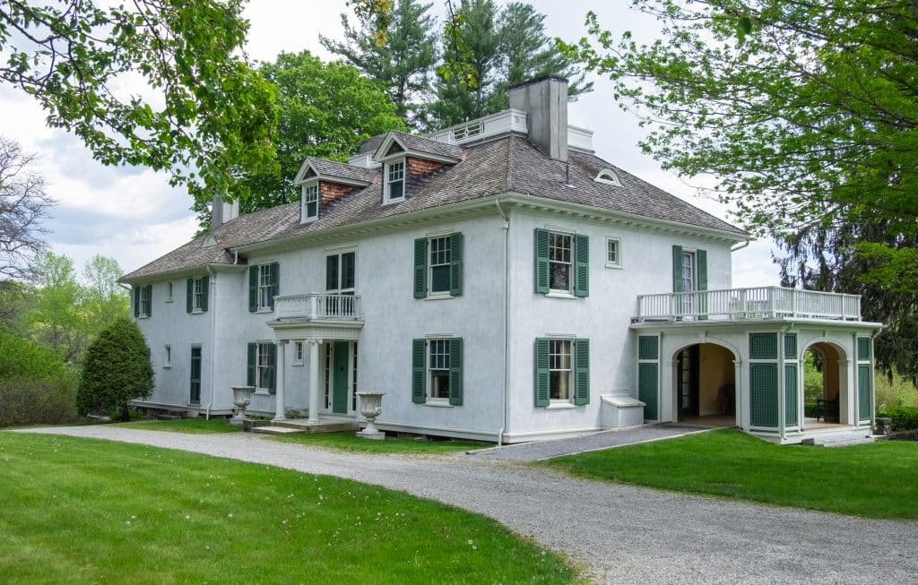 A big White House with a small sun room off to the side.