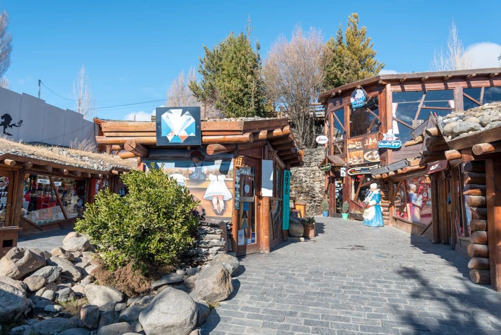 An outdoor market with lots of wooden log cabin-like buildings for indoor shops.