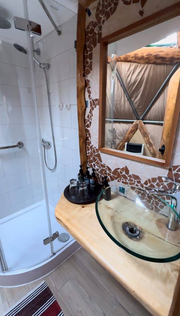 A small private bathroom with a shower stall and a sink.