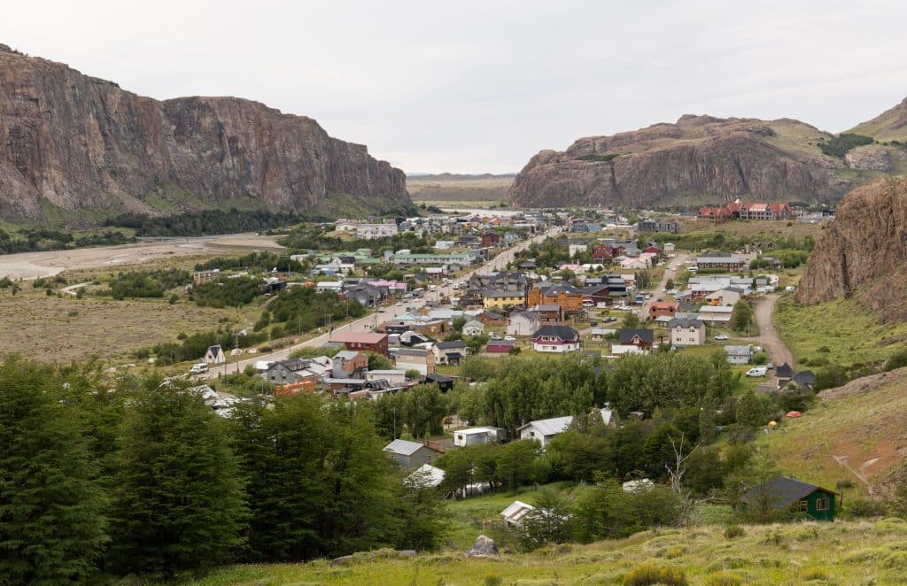 A small town of colorful small houses, surrounded by tall mountains on all sides.