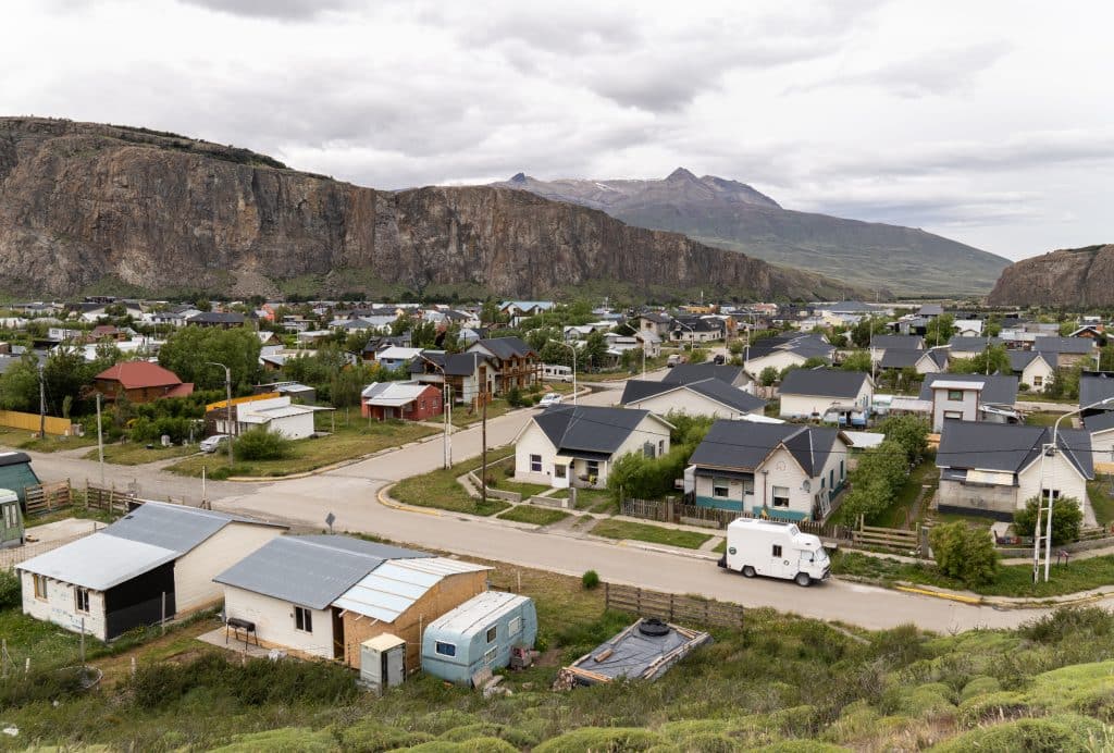 A small town filled with houses, surrounded by mountains on each side.