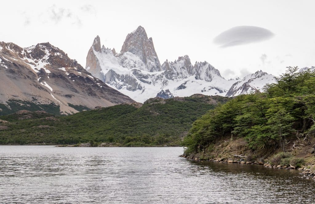 The jagged gray mountain range of Fitz Roy and a still gray lake in front of it.