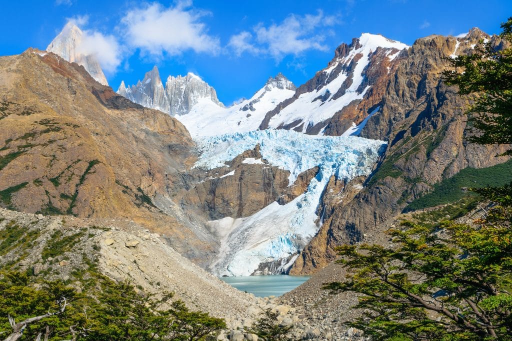 A mountain range with a blue and white glacier spilling between the peaks.