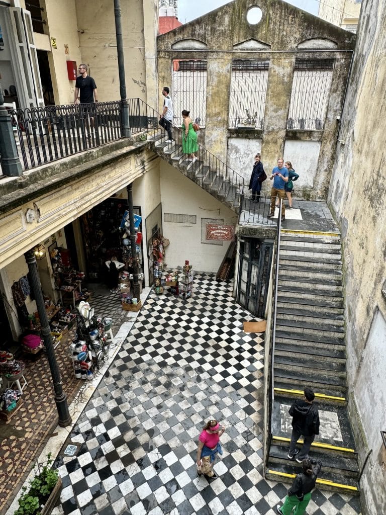 The view over a staircase in a courtyard in Buenos Aires, the ground patterned in black and white checked tiles.