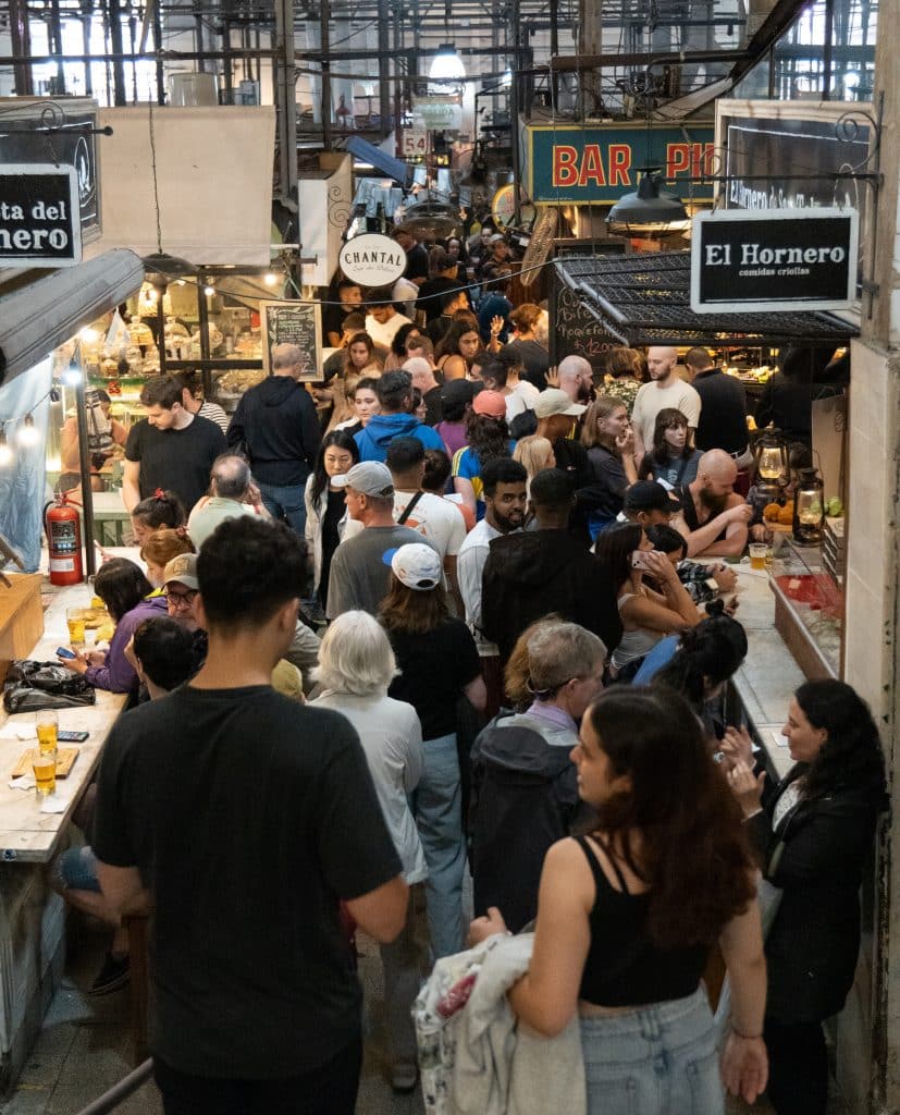 Big crowds of people inside an indoor market in Buenos Aires.