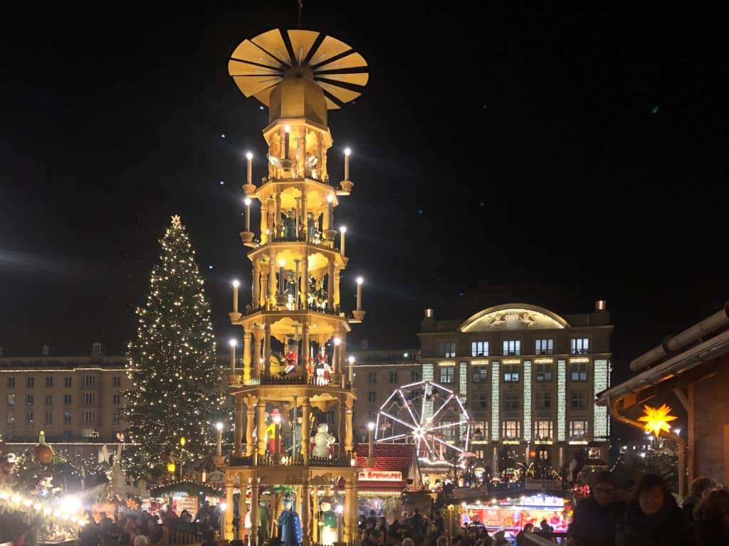 A Christmas market in Dresden, Germany, with a big tree and a tall wooden tower of spinning Christmas characters.