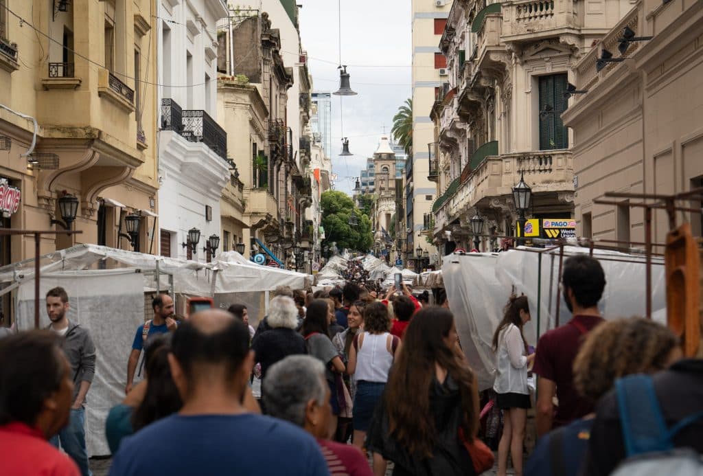 Big crowds of people at a street market in Buenos Aires, stalls on each side of the pedestrian-only street.