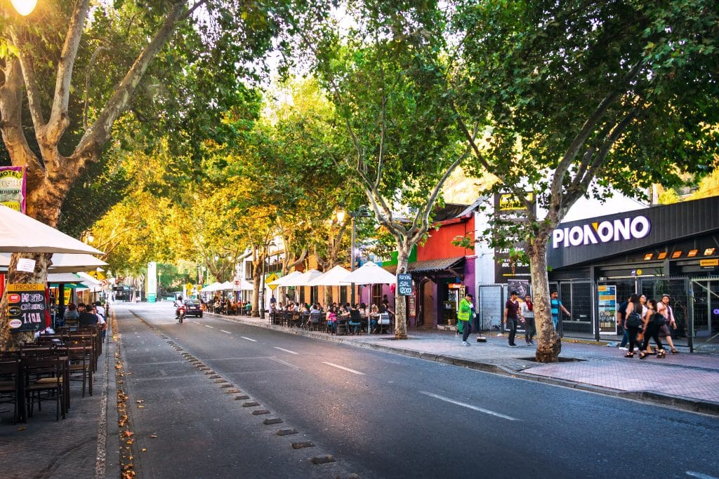 A bustling neighborhood in Santiago with lots of restaurants and tree-lined streets.