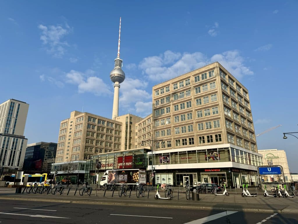 Berlin buildings and its TV tower underneath a bright blue sky.