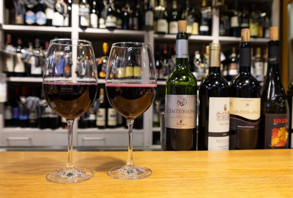 Two glasses of red wine on a table in a bar in Bologna, Italy.