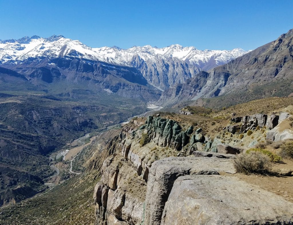 A dramatic canyon in Chile, edged with snow-covered mountains.