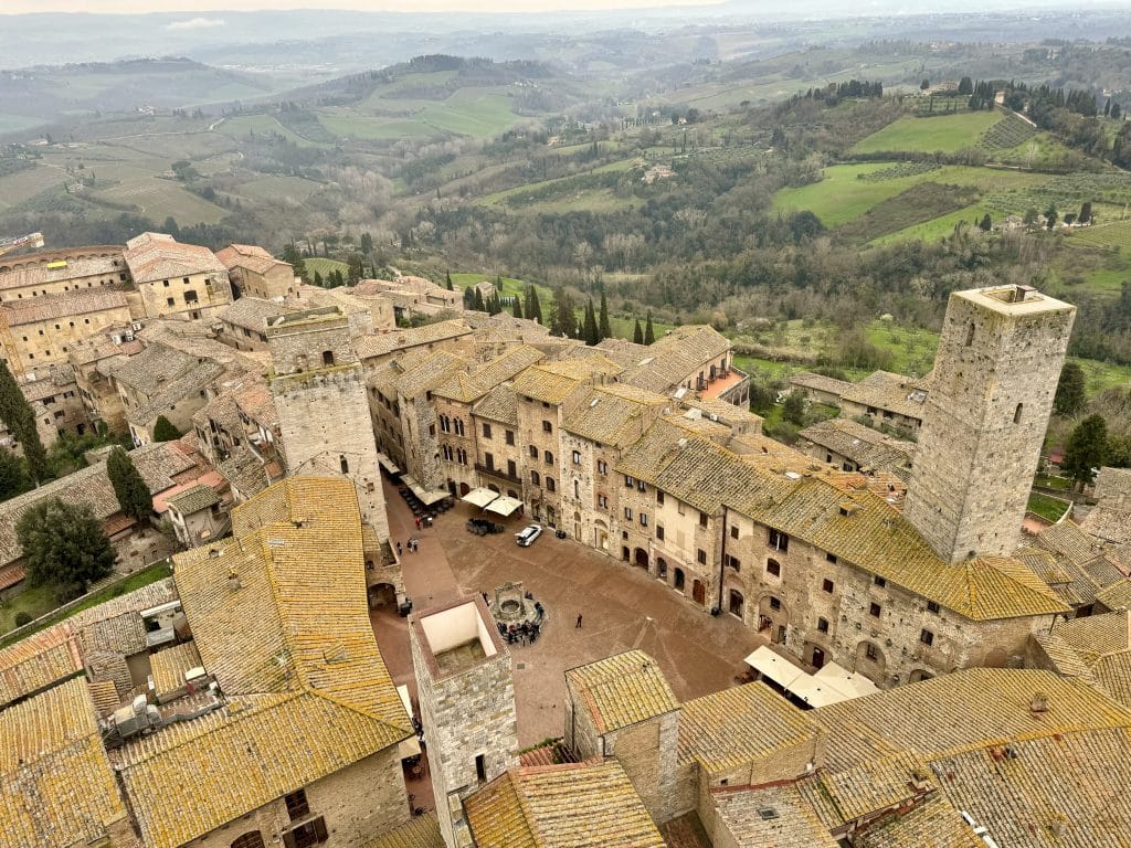 The tiny walled town of San Gimignano, surrounded by green Tuscan hills on all sides.