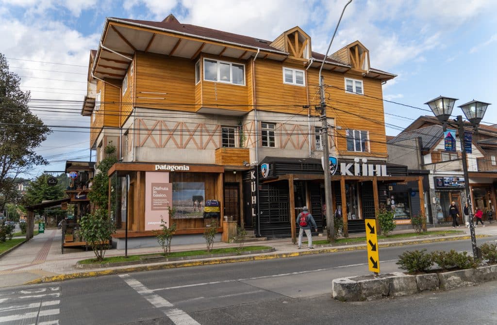 A tall wooden building in Puerto Varas with a few boutiques on the ground floor.