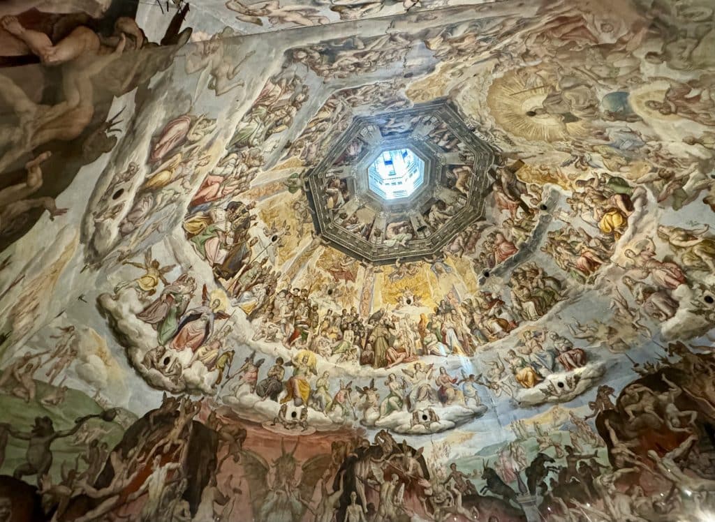 The ceiling of Florence's Duomo, with rows upon rows of circular angels looking toward the open center, which looks kind of like a portal to heaven.
