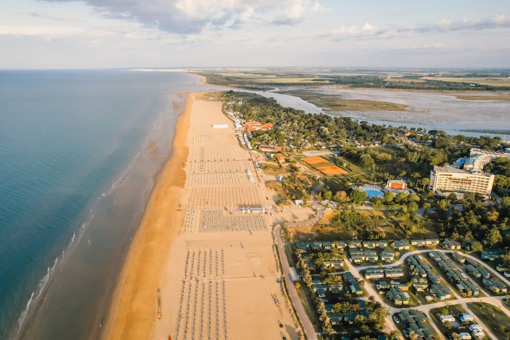 A Long Beach lined with lots of chairs and umbrellas, set on an Italian island.