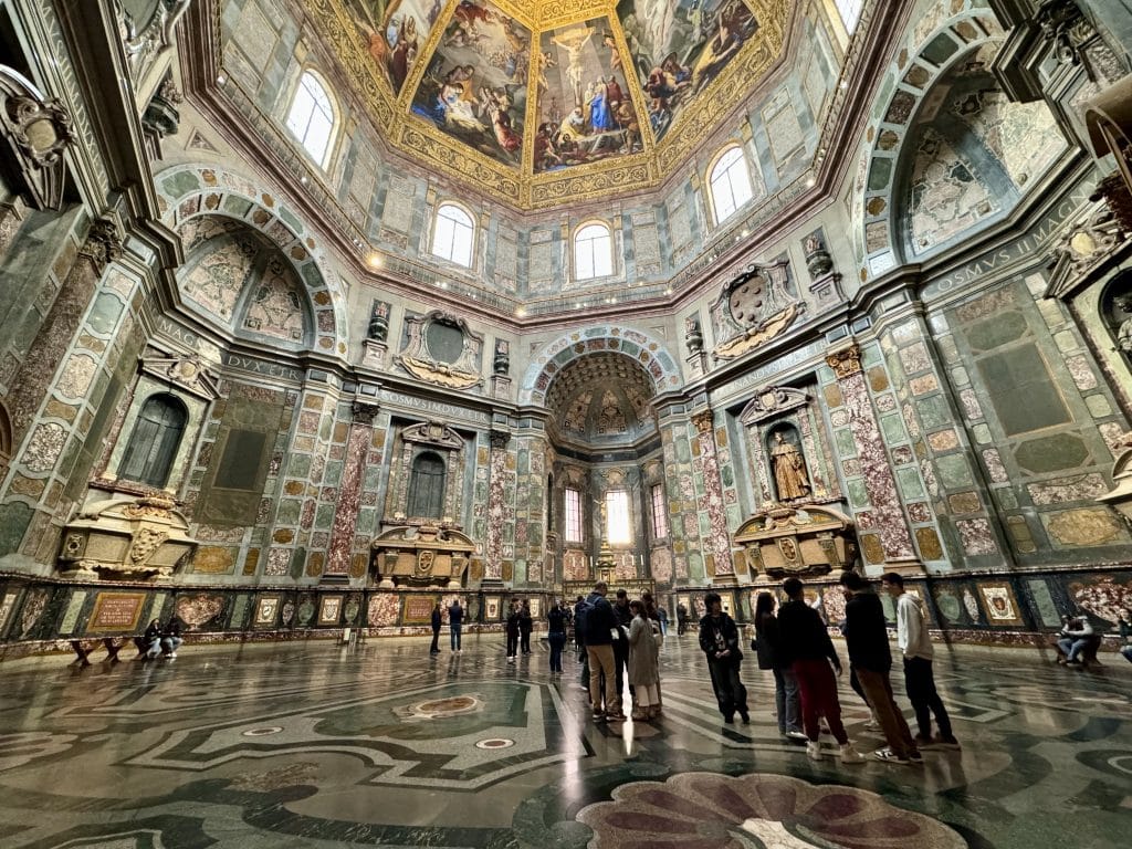 A giant chapel covered in intricate stonework in green, burgundy, and gold.