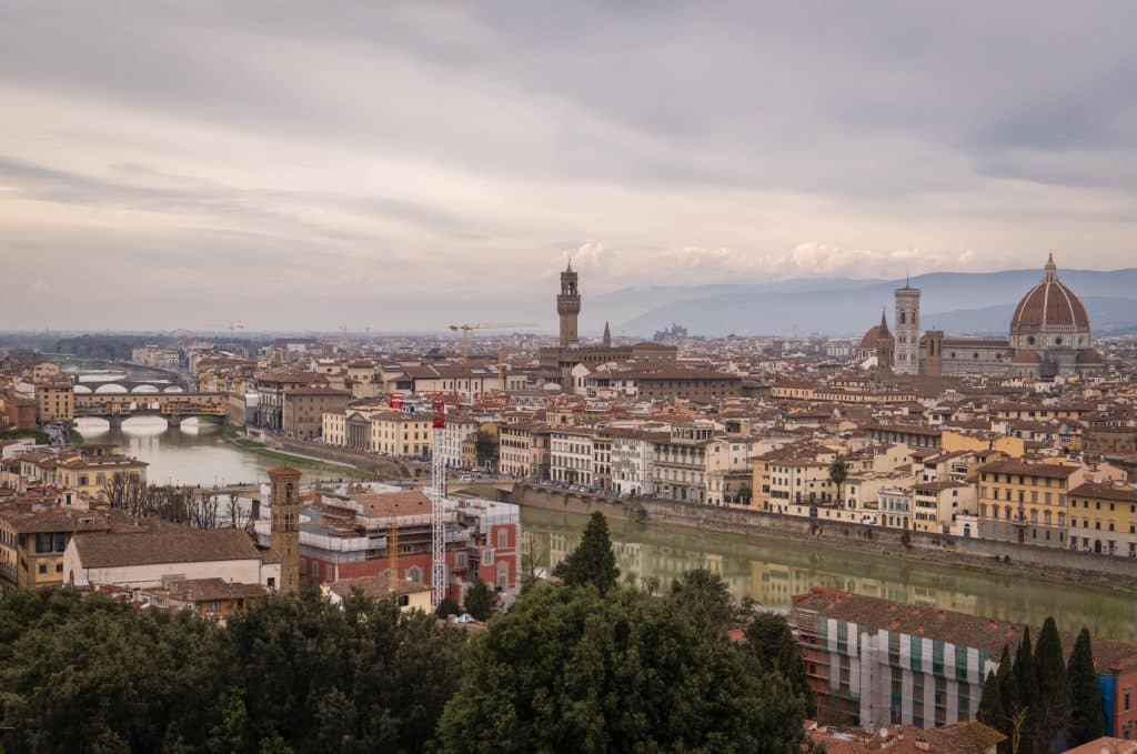 A view of the skyline of Florence, with the Ponte Vecchio crossing the river, the Palazzo Vecchio's tower sticking straight up, and the Duomo dominating everything.