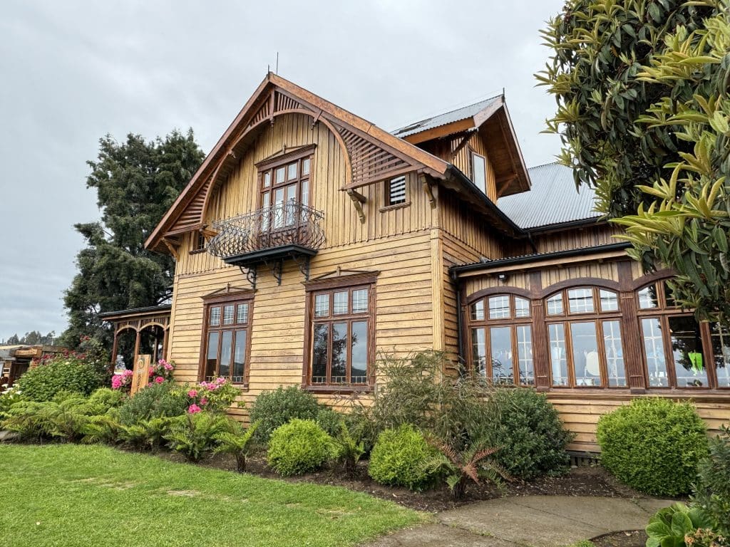 A yellow wooden house with brown trim in Frutillar, Chile.