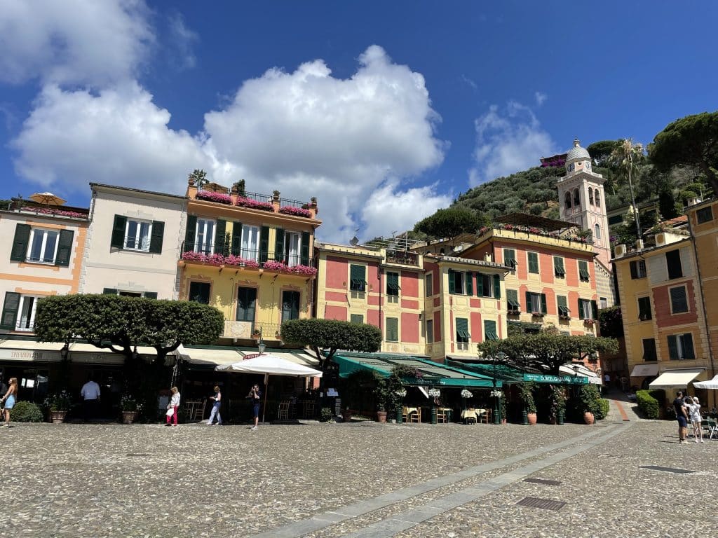 A big open piazza in Portofino, Italy, edged with sidewalk cafes.
