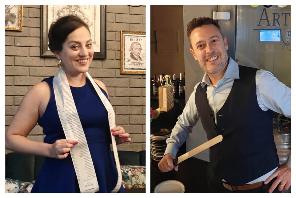 Kate and Charlie side by side. Kate has a very long receipt worn around her neck like a scarf.