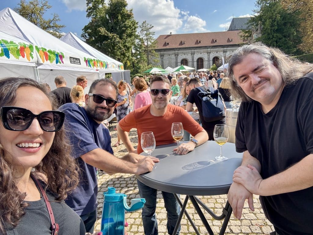 Kate and three friends at a wine festival in Prague. Kate has a water bottle; the others are drinking wine.