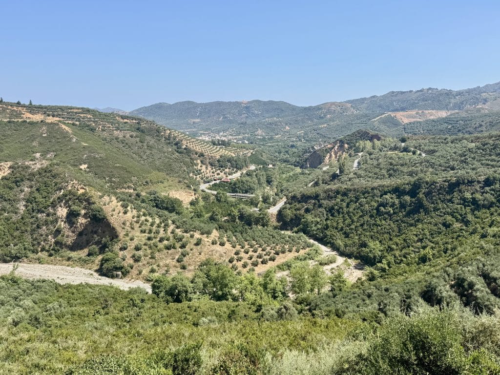 The rolling hills of the Greek countryside, some hills cultivated as farmland.