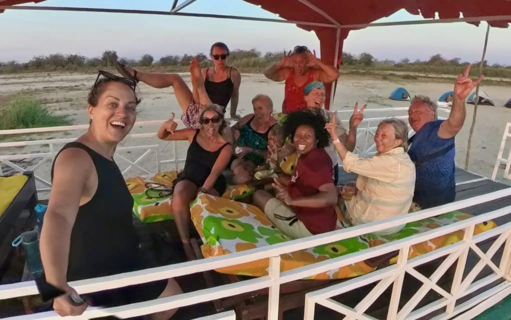 Kate and her travel companions on the top deck of a boat, making funny faces at the camera.