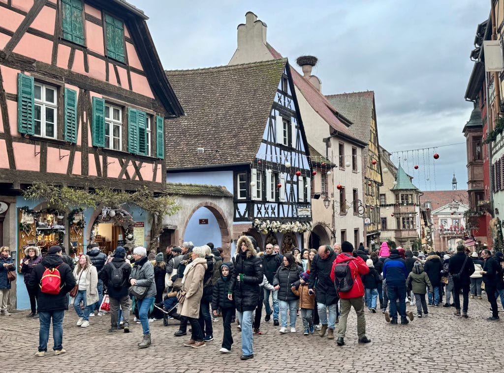 The town of Riquewihr in France, featuring colorful half-timbered houses covered with Christmas decorations.
