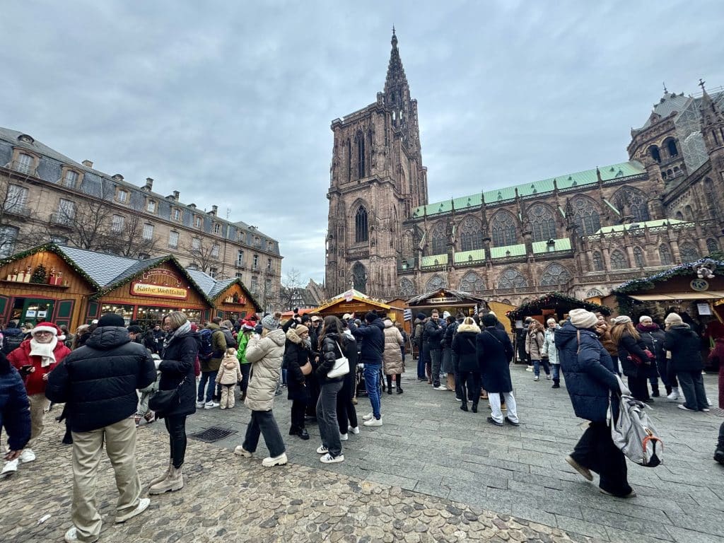 Strasbourg's main square and large cathedral, surrounded by little Christmas market huts.