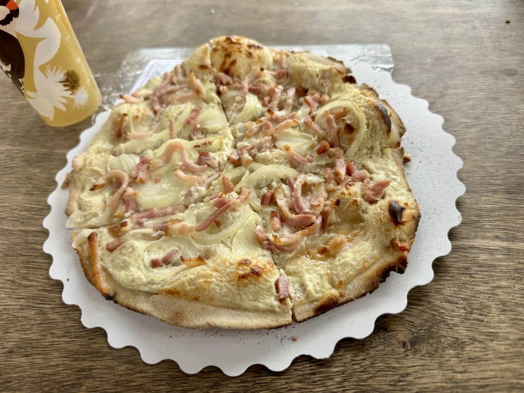 A tarte flambee: a flatbread topped with cheese, onions, and bacon lardons.