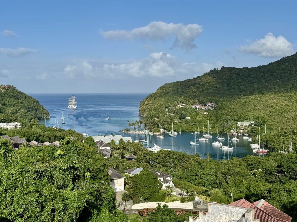 A small blue bay in St. Lucia filled with sailboats (and the big Royal Clipper ship), surrounded by lush green hills