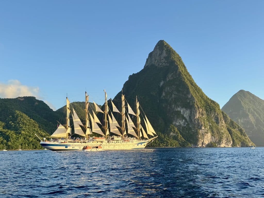 The Royal Clipper, the world's largest sailboat, dramatically set against the pointy green Piton mountains of St. Lucia.