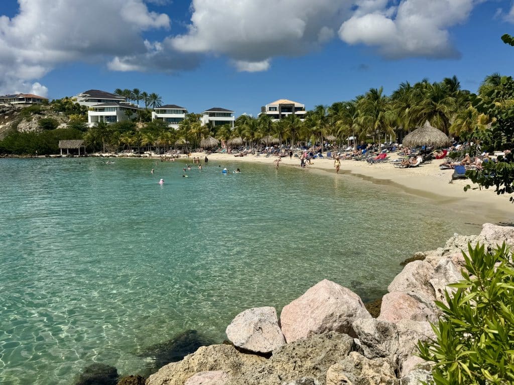 A beach in Curacao with endless calm turquoise water and soft sand.