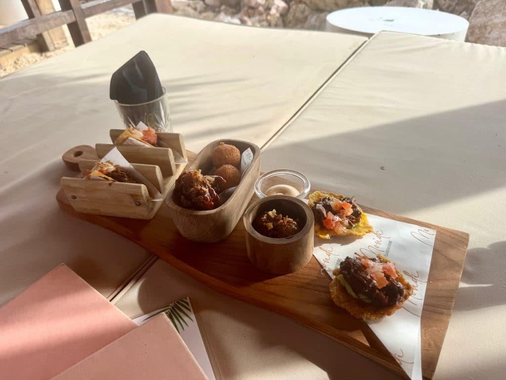 A platter covered with cheese balls, tacos, and tostadas.