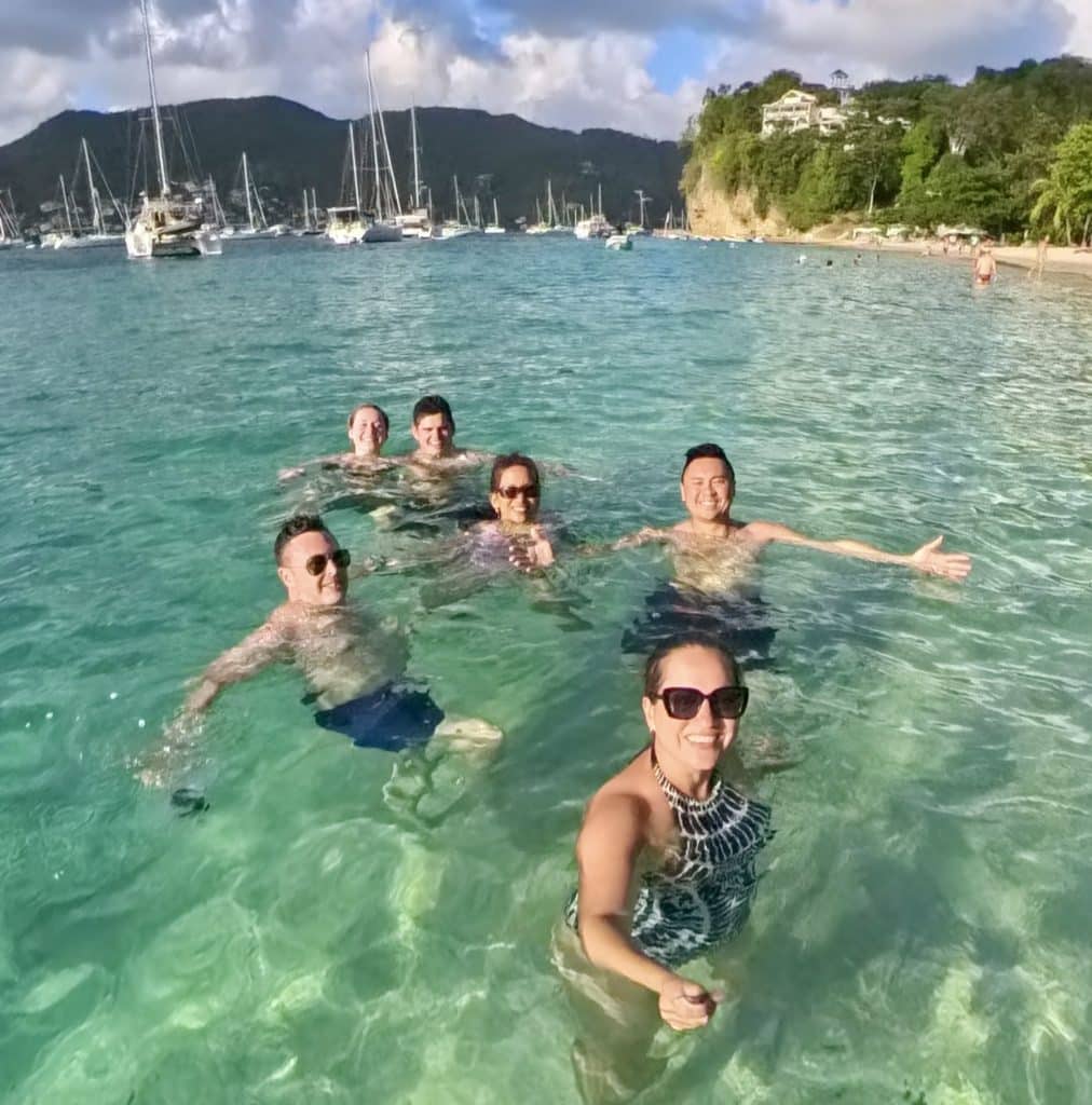 Kate and five friends swimming in turquoise water off a beach in Bequia.