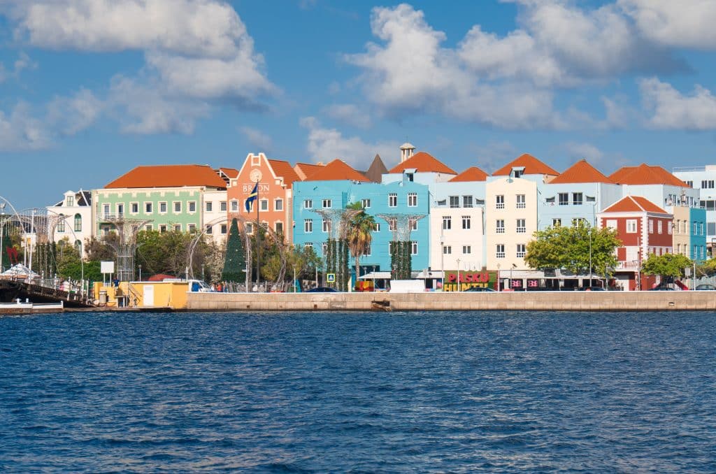 A row of brightly colored Dutch-style houses on the waterfront.