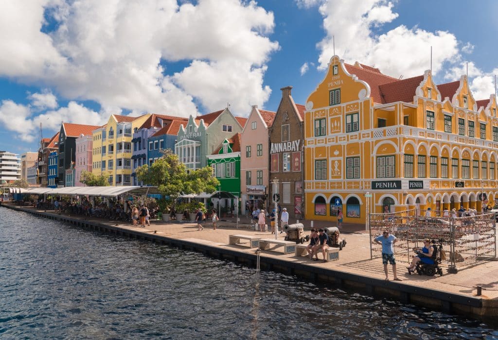 A row of bright and colorful houses in Curacao along the water's edge.