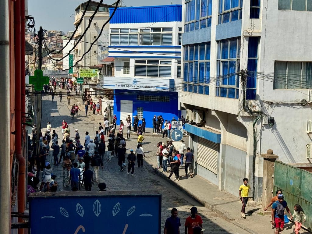 A group of people protesting on a busy city street in Madagascar.
