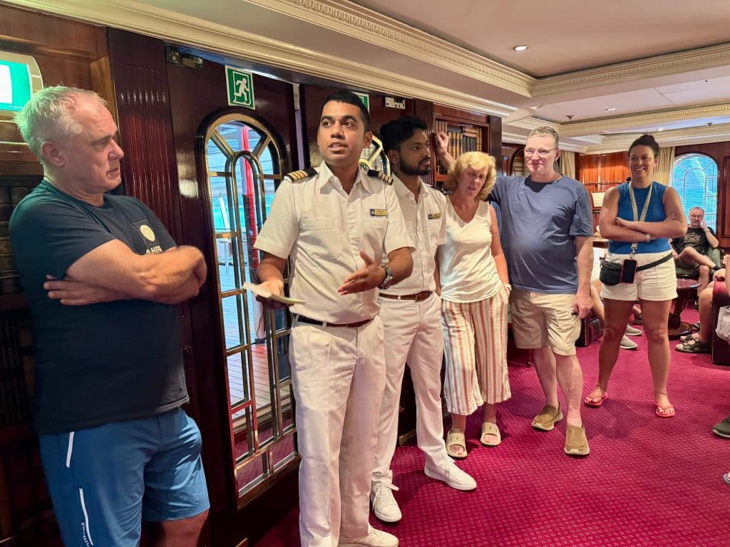 Chief engineer Hitesh, in his white officer uniform, and a few other crew members, as he gives a talk in the library.