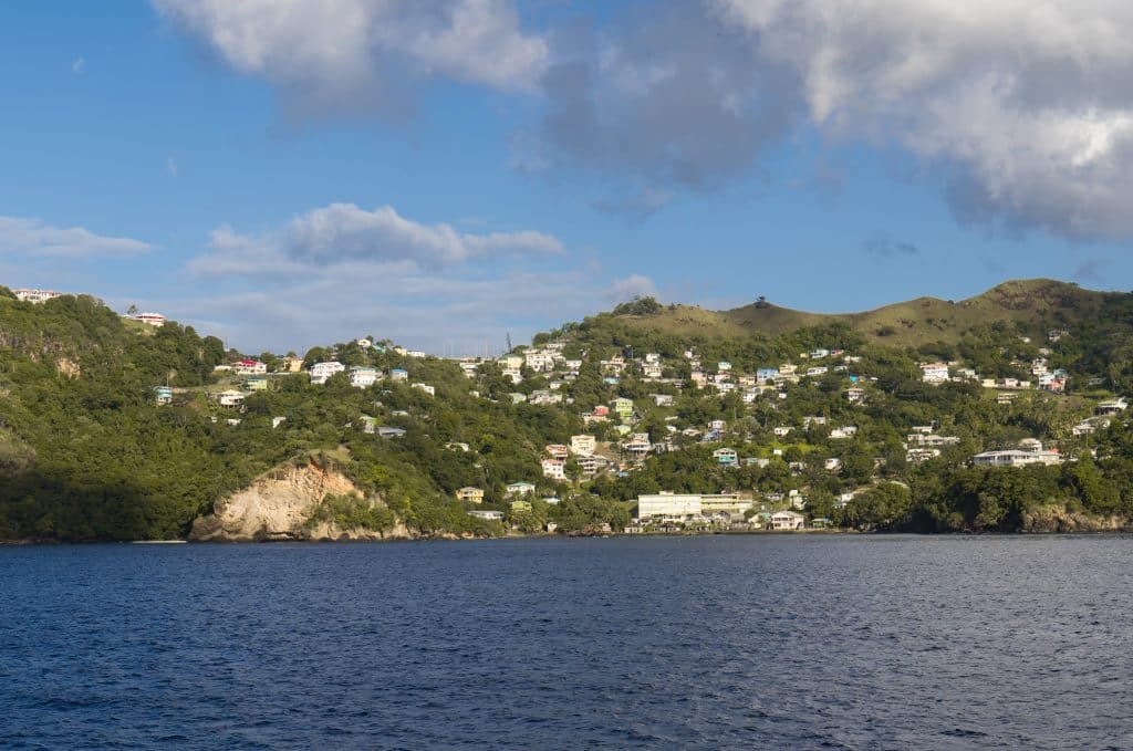 The green mountainous coastline of St. Vincent, with little houses built into the hills.