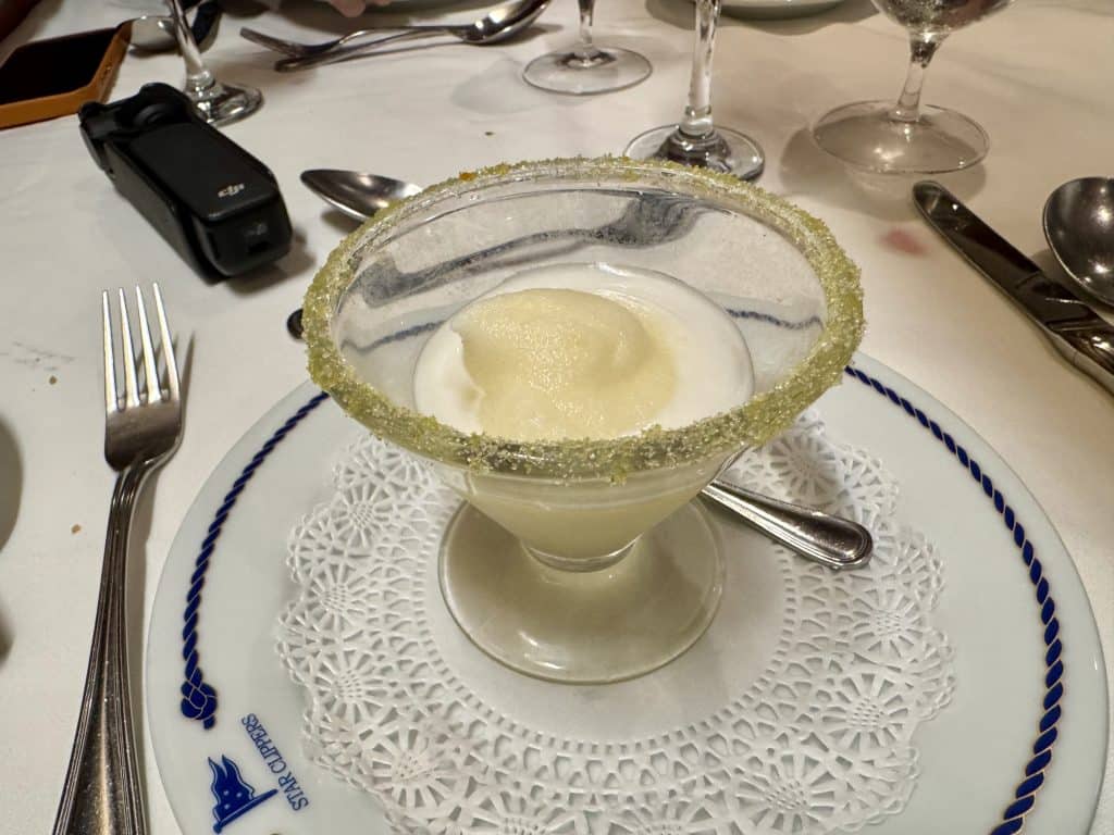 A bowl of pineapple sorbet edged with sugar.