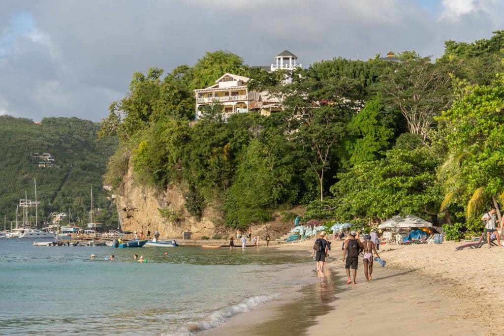 A big white wooden house built into the green, lush cliff overlooking Princess Margaret Beach.