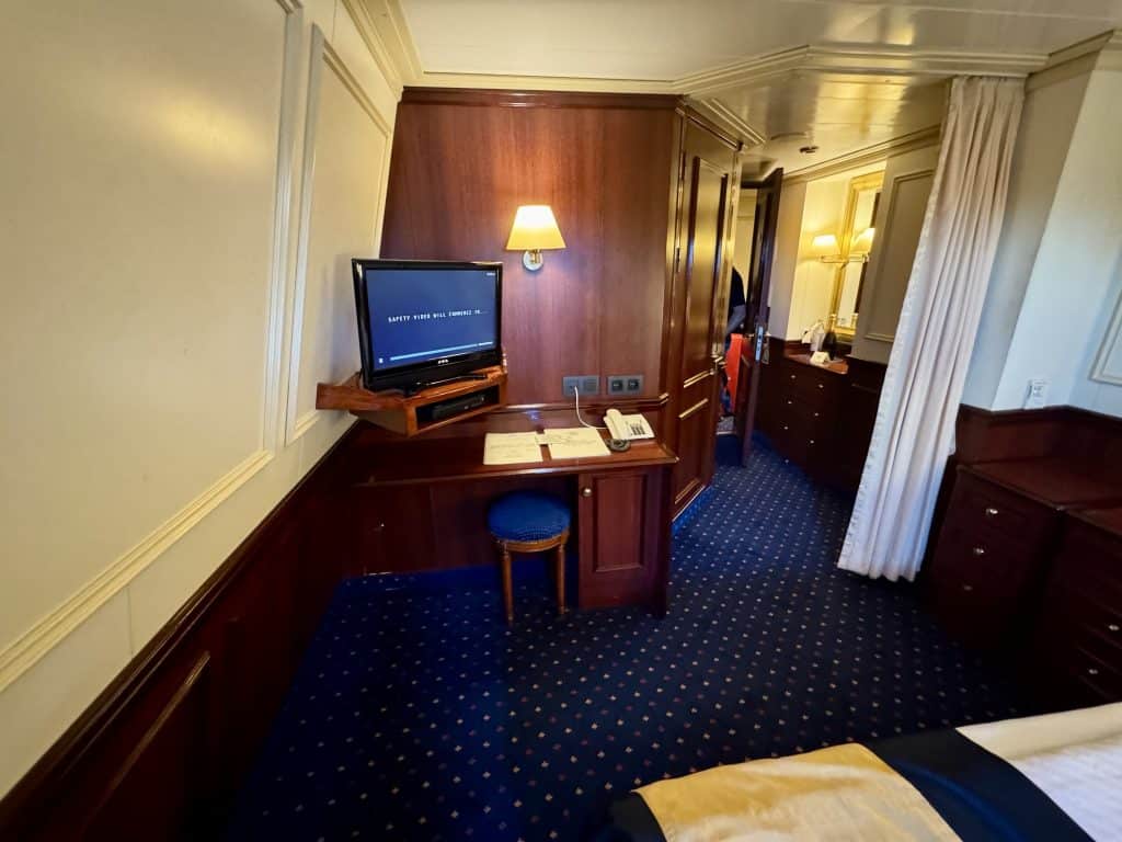 The other side of the cabin, with a small desk with a small flatscreen TV perched on it.