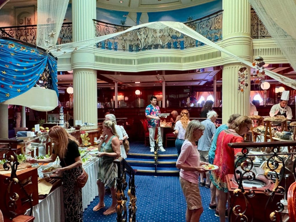 People getting food at a buffet in an elegant dining room.